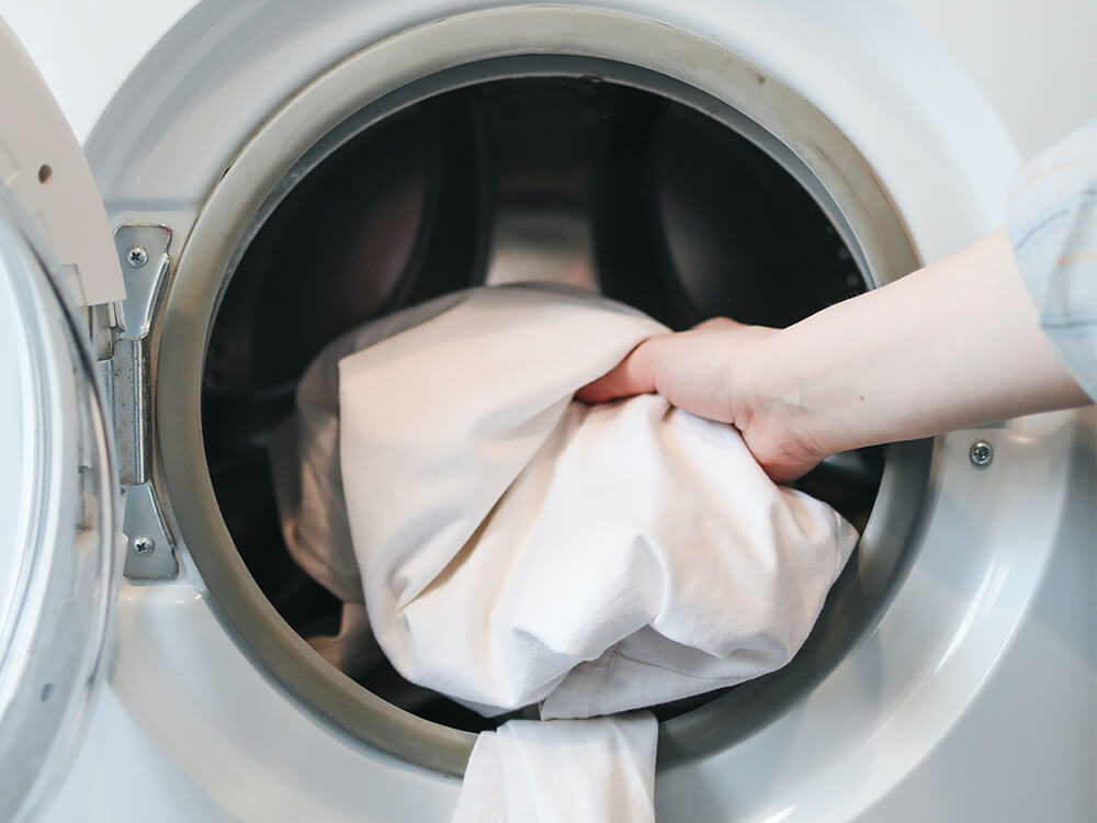 Hand taking laundry out of the dryer